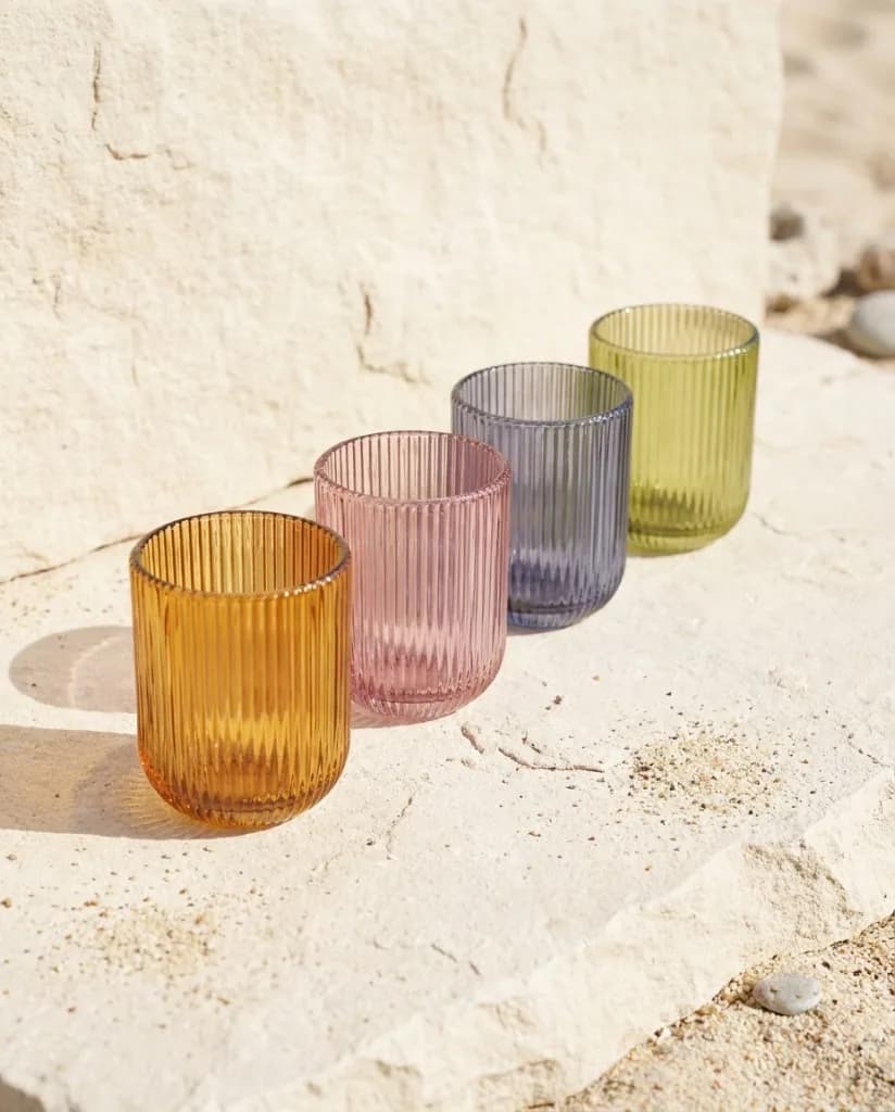 Colored ribbed glass tumblers on natural stone